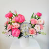 Pink and white floral arrangement in a white ribbed vase