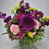 Purple and pink mixed bouquet in a clear glass vase