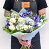 Handheld bouquet of white roses, blue hydrangea, and purple irises
