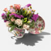 Floral arrangement in a floral teacup with pink and lavender blooms