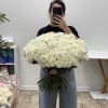 Large bouquet of white roses held by a person taking a mirror selfie