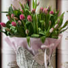 Pink tulips in a flower basket with baby girl accents.