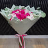 A romantic arrangement of soft blush pink and rich berry roses, accented