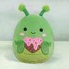 Green plush character with antennae holding a pink sprinkled heart-shaped treat.