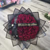 Bouquet of deep red roses wrapped in black paper with a 