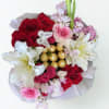 A romantic floral box featuring red roses, blush blooms, elegant white lilies