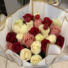 Red, pink and creamy white roses arranged in a lush, rounded bouquet