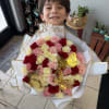 A lush, rounded spray of roses in blush pink, deep red, creamy