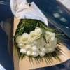 Bouquet of white roses wrapped in brown and white paper
