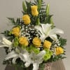Sunlit yellow roses and large white lilies unite in a wicker basket