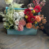 A sunlit mix of garden roses, gerbera-style blooms and playful accents arrives