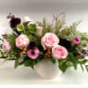 Pink roses and mixed flowers arranged in a white vase