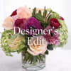 Mixed pink and burgundy flowers arranged in a clear glass vase