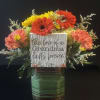 Bright mixed gerbera, carnations and pale hydrangea in a glass vase with