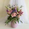 Pink and purple floral arrangement in a ribbed vase
