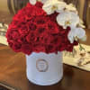 Red rose arrangement in a white hat box with white orchids