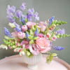 Soft pink roses and tulips mingle with lavender snapdragons and pale lisianthus