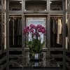 Pink orchids in a silver bowl on a black marble table