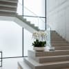 White orchid arrangement in a shallow white bowl on a staircase landing