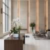 White orchids in a white pot on a wooden table in a lobby