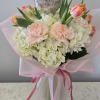 A full, cheerful Mother's Day flower arrangement centered on parrot tulips and