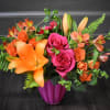 Bouquet of orange lilies and pink roses in a magenta vase