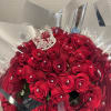 Bouquet of red roses wrapped in silver paper with a jeweled crown