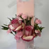 Pink roses and carnations arranged in a pink gift bag with ribbon and butterfly accents.