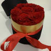 Red roses in a black round box with a red ribbon