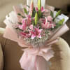 A cluster of open pink lilies surrounded by soft pink carnations and