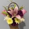 A large pink lily takes center stage in this spring-ready flower arrangement