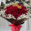 Bouquet of red roses with white baby's breath and a pink ribbon