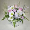 Pale pink roses and white daisy-like blooms in this watering can. Airy