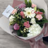 Bouquet of pink and white flowers wrapped in blush paper