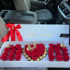 Red roses and chocolates arranged in a gift box with a ribbon