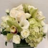 White roses, calla lilies, and hydrangeas in a square vase