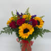 Bouquet of red roses and yellow sunflowers in a glass vase