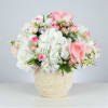 Pink and white rose bouquet in a cream vase