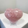 Pink heart-shaped crystal on a clear stand