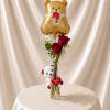 A romantic floral gift featuring fresh red roses, a soft plush teddy