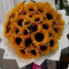 Large hand-tied bouquet of bright yellow sunflowers wrapped in white paper