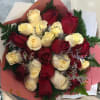 Bouquet of red and cream roses wrapped in pink paper