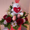 Red roses and pink flowers arranged with a teddy bear and 