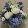 A cool, refined arrangement of blue delphinium and hydrangea with creamy white