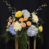 Mixed bouquet with yellow and peach roses, blue hydrangeas, and white chrysanthemums
