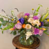 Mixed bouquet in a glass vase with purple, pink, white, and orange flowers