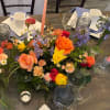 Colorful floral centerpiece with roses, daffodils, and purple blooms on a table