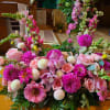 Pink floral arrangement with roses, dahlias, and snapdragons on a table