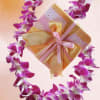 Purple-and-white lei with a wrapped chocolate gift box