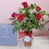 Red roses in a glass vase with a red ribbon